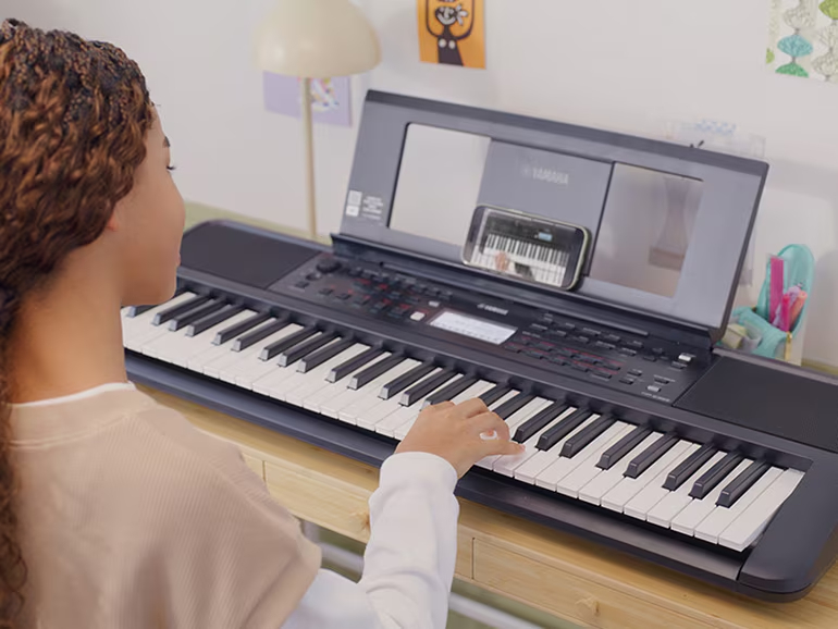 Girl is playing the YPT-380 with satisfaction.