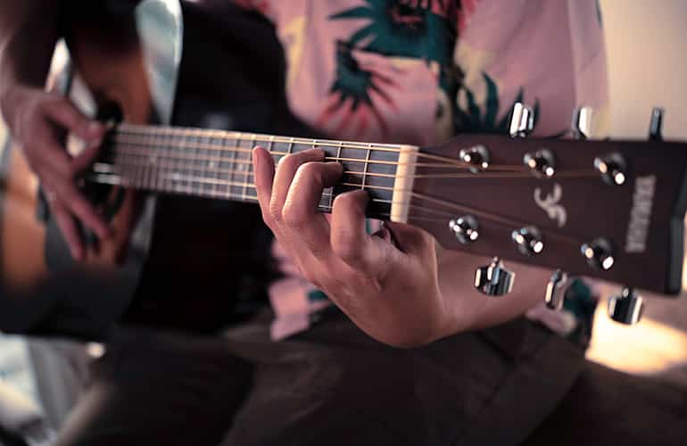 Person playing an F310 Tobacco Brown Sunburst acoustic guitar. Close-up of F310 neck and head.